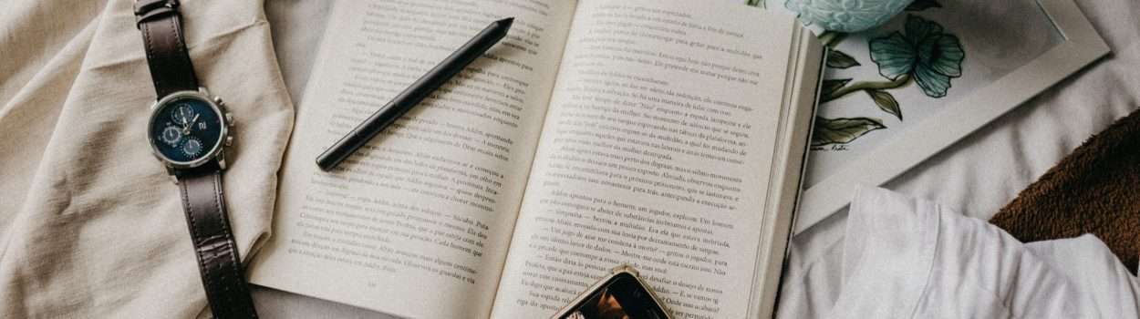 top-view-of-black-pen-on-white-opened-book