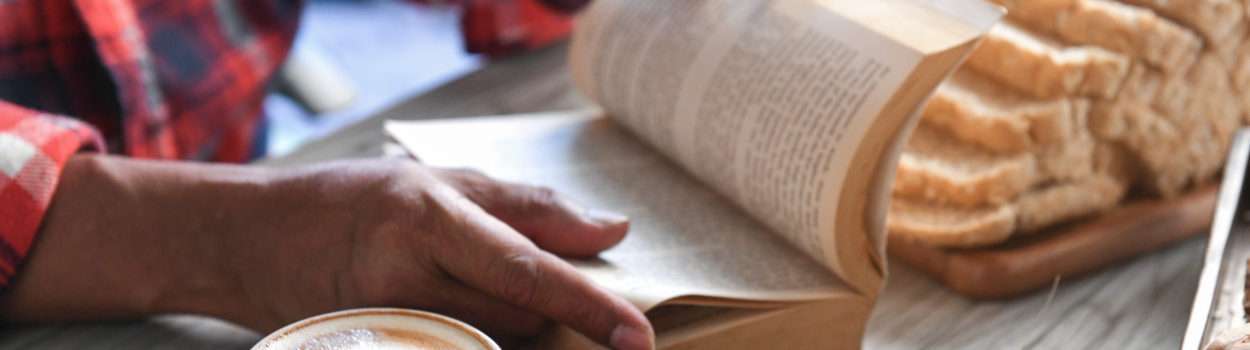 Man reading the book with coffee